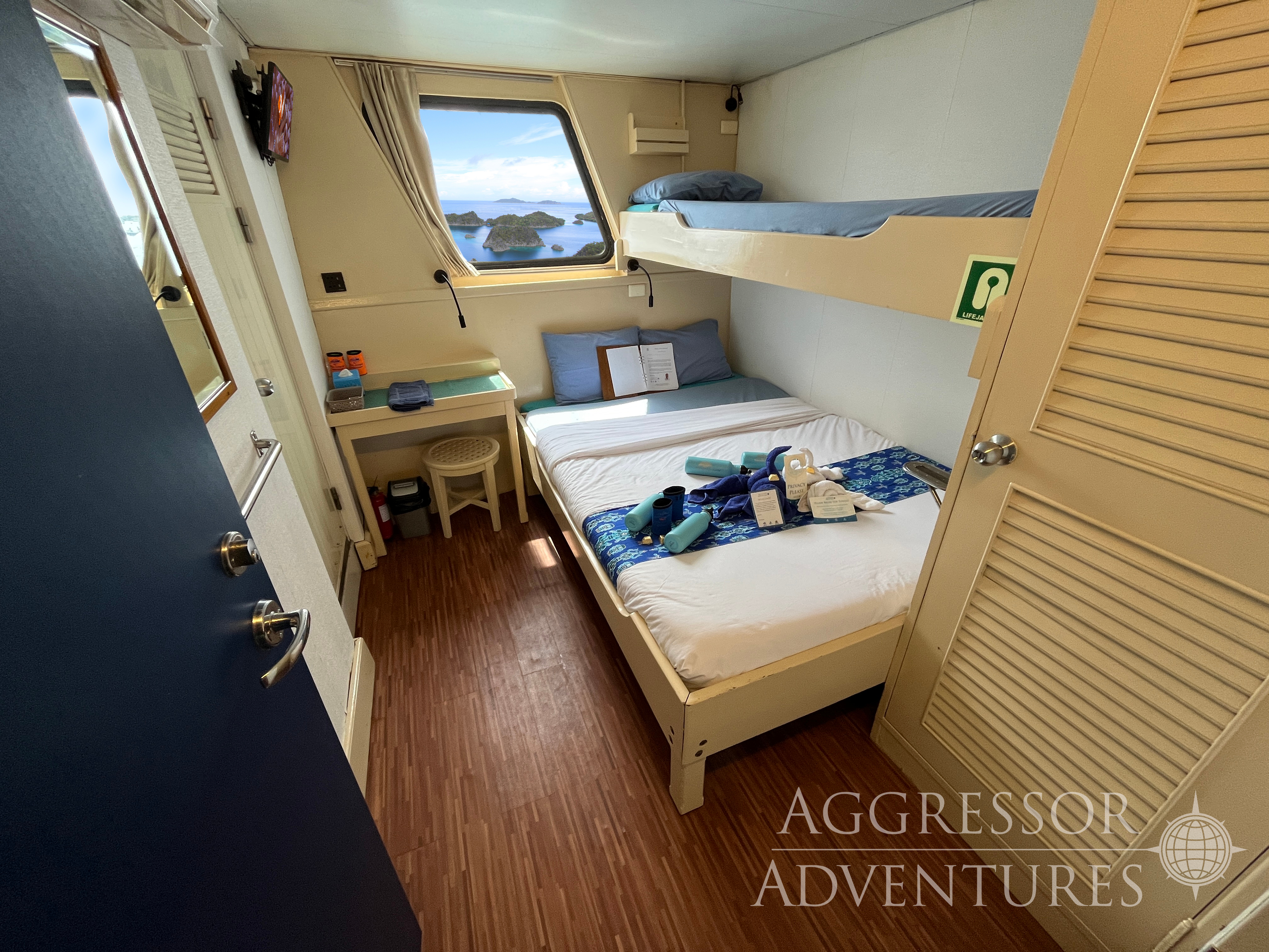 master stateroom with queen bed and picture window on Raja Ampat Aggressor